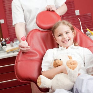 Little girl smiling in a pediatric dental chair
